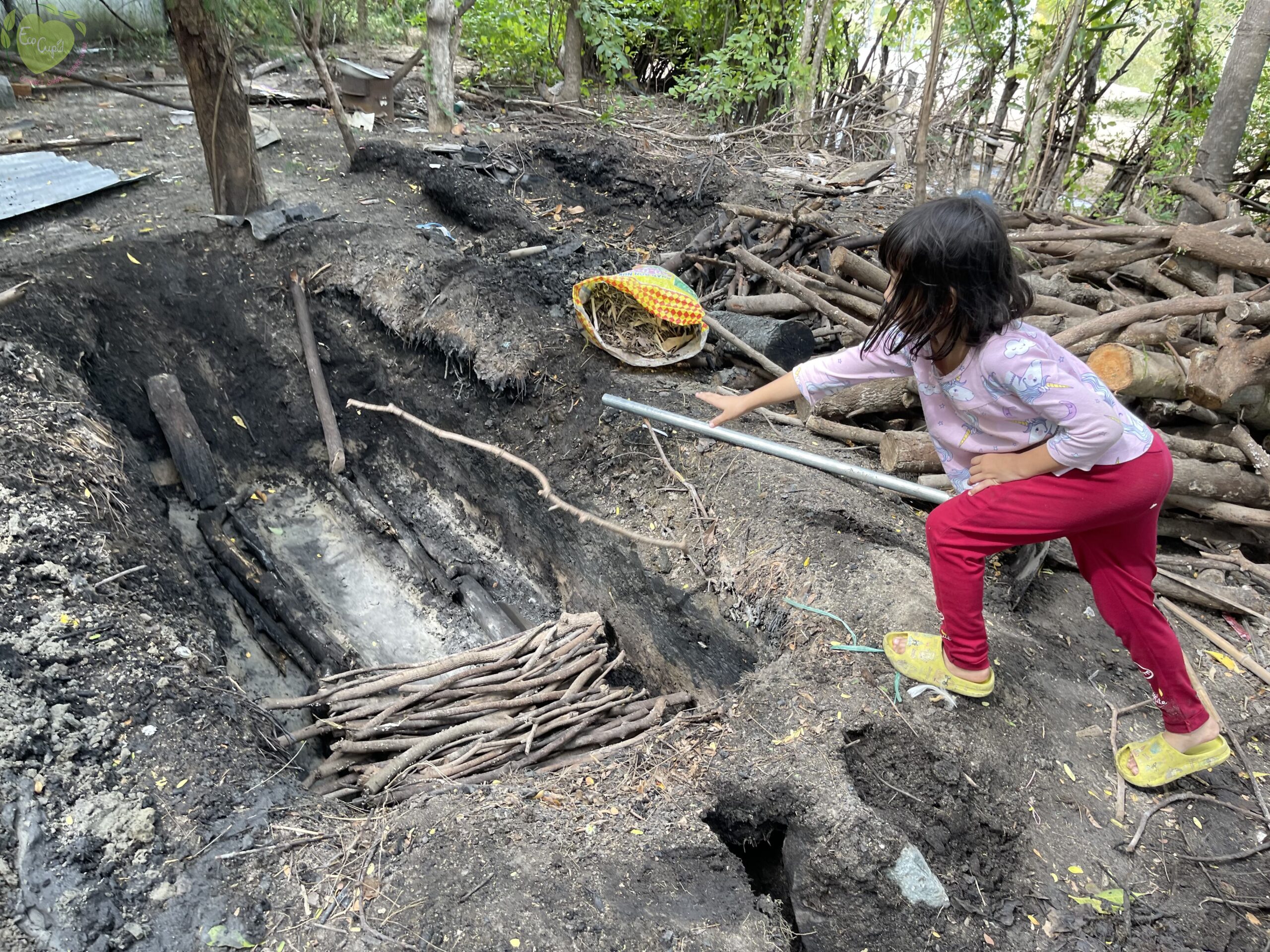 Mr Jaka’s daughter is helping out with building the base for the charcoal pit. (huy)