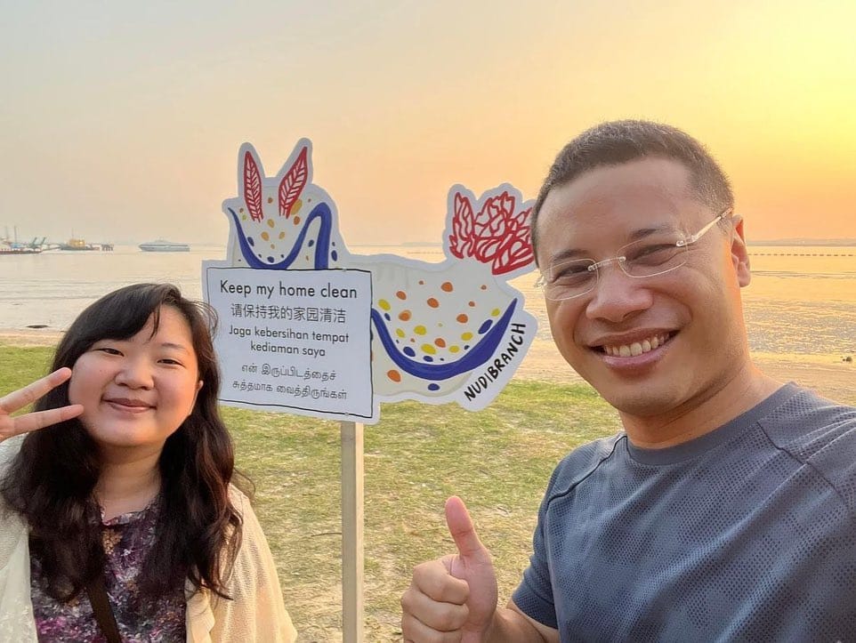 Dorcas poses with Singaporean Minister Desmond Lee, an Orang Pulau community advocate, in front of one of several intertidal awareness signs installed at Changi beach. Photo courtesy of National Parks, Ting Wai Kit.