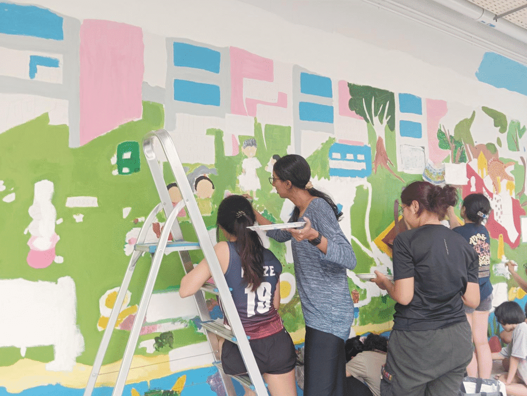 Volunteers paint “The World We Want”, a community mural emphasizing the importance of keeping neighbourhoods clean. Photo courtesy of Dorcas Tang Wen Yu.