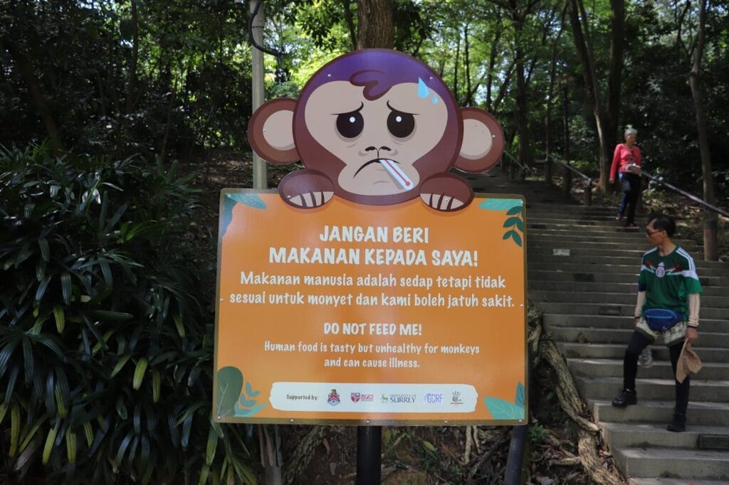 Placed along forest trails, ANP-led signboards remind visitors that human food harms macaques. Photo courtesy of Animal Neighbours Project.